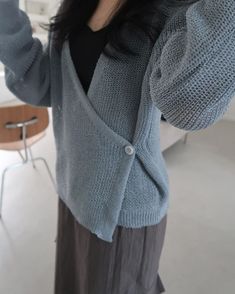 a woman is taking a selfie with her cell phone while wearing a cardigan