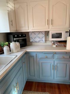 a kitchen with blue cabinets and white appliances