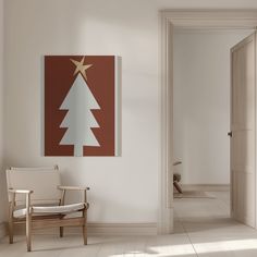 a white chair sitting in front of a wall with a christmas tree painting on it