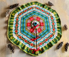 a crocheted doily with pine cones around it