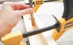 a person is measuring the length of a piece of wood with a pair of tools