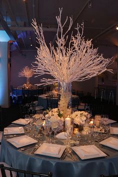 the centerpieces are decorated with white flowers, candles and glass vases for an elegant touch