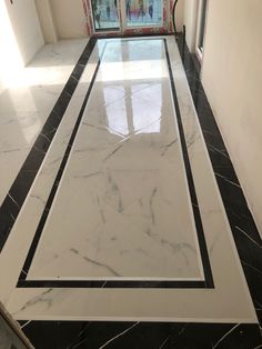 a hallway with black and white marble flooring