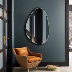 a chair sitting in front of a wall with a mirror on it's side