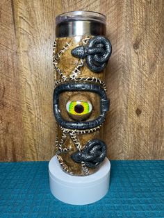 a metal cup with an evil eye and chains around it