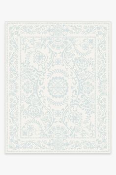 a light blue and white rug with an intricate design