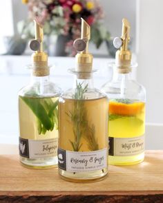 three bottles filled with liquid sitting on top of a wooden table