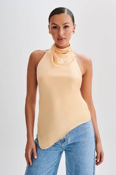 Elevate your everyday.Introducing the SERAPHINE Satin Halter Top, a vision of elegance and allure. Crafted to perfection, this top features a stunning halter neckline adorned with a graceful cowl detail, adding a touch of sophistication to your look. The low back design exudes understated glamour, while the asymmetrical hemline adds a modern twist. Complete with a delicate button closure at the neckline, it ensures a secure and stylish fit. Lined for comfort and coverage, this top promises a lux Chic Cowl Back Summer Tops, Chic Summer Tank Top With Cowl Back, Elegant Backless Tank Top For Spring, Spring Party Top With Cowl Back, Chic Cowl Neck Halter Top, Chic Spring Halter Neck Camisole, Elegant Spring Camisole Halter Top, Chic Fitted Cowl Neck Tank Top, Cowl Neck Tops For Night Out In Spring