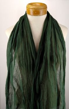 This hand dyed gauze scarf is in a dark green similar to myrtle leaves. Wear as a neck wrap, head scarf, head wrap and more.  The gauze is very lightweight and sheer. With raw edges and loose threads, it is ready to ship. Scarf is 78" (193 cm) long and 16" (41 cm) wide. The hand dyeing process gives the scarf some subtle color shifts. I use permanent, non fading fiber reactive dye which will not wash out. Can be machine washed and dried if you want to increase the loose threads along the edges. Green Bohemian Wrap Scarf, Green Bohemian Silk Scarf One Size, Luxury Green Shawl-style Scarf, Elegant Green Scarf, One Size, Myrtle Green, Hand Dyed Scarves, Green Wrap, Artistic Hand-dyed Green Scarves, Neck Wrap