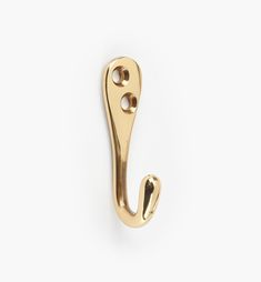 a gold metal hook on a white background with the letter j in it's center