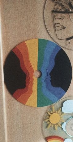 two cd's sitting on top of a table next to each other with different colored discs in front of them