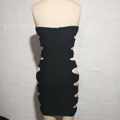 a mannequin wearing a black dress with holes in the front and bottom part