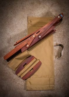 two wooden utensils sitting on top of a pair of khaki pants