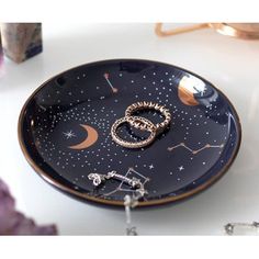 a plate with two rings on it sitting next to a candle and some crystal rocks