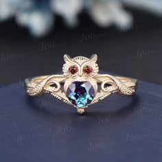 an owl shaped ring with blue topazte and garnets on the sides