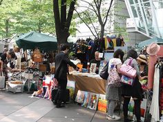 people shopping at an outdoor flea market in the city