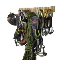 there are many different tools hanging on the wall and in front of it is a climbing rope