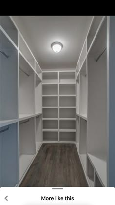 an empty walk - in closet with white shelving and wood flooring is shown