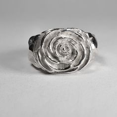 **Please note that we dispatch on Tuesdays unless special delivery express option is paid for** Sterling silver Camellia ring. Original design carved in wax then lost wax cast into solid sterling silver.  Piece weighs approximately 17g.  Shown in a size N, and adjustable to ring sizes I-S.  A significant size adjustment may alter the appearance slightly.  First class post included, with a supplement for special delivery. Unique Hand Cast Sterling Silver Signet Ring, Carved Sterling Silver Rings For Anniversary, Carved Sterling Silver Signet Ring Gift, Hand Cast Sterling Silver Engraved Ring, Silver Hand Cast Engraved Ring For Promise, Hand Cast Silver Rings For Anniversary, Anniversary Sterling Silver Carved Rings, Hand-cast Engraved Sterling Silver Ring, Hand Cast Engraved Silver Sterling Ring