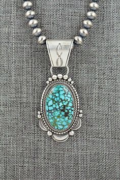 This natural Kingman turquoise and brushed-finish sterling silver necklace was made by Navajo silversmith Tom Lewis. The top of the bail is signed Tom Lewis and stamped sterling.Necklace: 18"Bead size: 1/4" x 1/4"Pendant Length: 2 7/8"Pendant Width: 1 1/4"Free shipping on all orders! We ship with USPS and always include tracking. All orders ship within a day of payment.Returns are accepted up to 30 days after you receive your order. Just send us a message. Our shop offers cash back or store credit. The item must be returned in new condition. Southwestern Style Engraved Turquoise Necklaces, Southwestern Engraved Turquoise Necklace In Sterling Silver, Silver Turquoise Pendant Necklace With Patina, Silver Pendant Turquoise Necklace With Patina, Collectible Sterling Silver Turquoise Necklace With Patina, Sterling Silver Turquoise Necklace With Patina, Southwestern Silver Necklace With Patina, Tom Lewis, Sterling Necklace