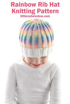 image showing a girl in a white shirt wearing a knit hat with a pattern of white and rainbow striped ribbing and a fully white folded brim. She is looking down at her lap in front of a white background Knitting Space, Stranded Knitting, Ribbed Hat, Window Crafts