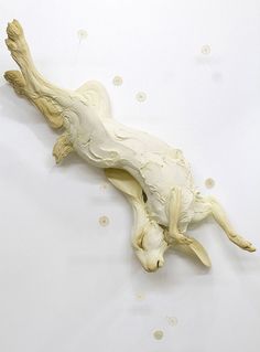 a sculpture of a dog laying down on its back with it's head in the air