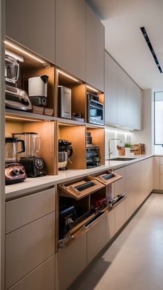 an open drawer in the middle of a kitchen with lots of cabinets and appliances on it