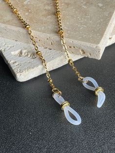 This beautiful high quality satellite chain is heavily plated in non tarnish 24K gold. The flattened links are soldered closed for strength and durability. This excellent quality gold chain is delicate yet very sturdy and will hold your expensive glasses safe and secure when not in use. **Measures 26 inches. **High quality 24K gold chain is finished off with clear eyeglass grips with gold plated slide adjusters for a secure hold on glasses arms. **Your package will arrive beautifully packaged an Metal Glasses Chains As Gift, Gold Chain Glasses Chain As Gift, Metal Glasses Chain With Adjustable Chain As Gift, Adjustable Gold Glasses Chains For Gift, Gold Chain Glasses Chains For Gifts, Gold Minimalist Glasses Chains With Adjustable Chain, Gold Chain Glasses Chains Made Of Glass For Gift, Modern Metal Glasses Chains With Adjustable Chain, Silver Delicate Metal Glasses Chain