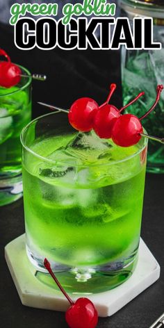 the green cocktail is garnished with cherries