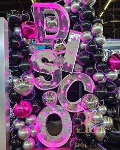 the number 50 is surrounded by balloons and disco balls in pink, silver and black