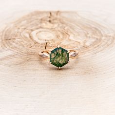 a green ring sitting on top of a piece of wood