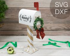 a white mailbox with a wreath on it next to green ribbon and christmas decorations