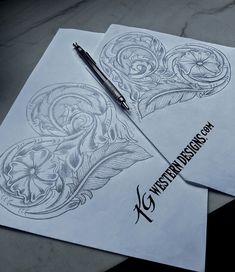 two sheets of paper with designs on them, one has a pen and the other has a drawing