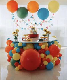 a table topped with balloons and a cake