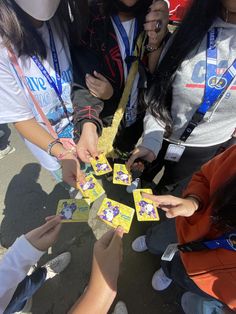 a group of young women standing next to each other holding onto small yellow boxes with pictures on them