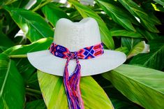 "These braided hat bands will liven up your Spring and Summer wardrobe. They are carefully woven together by hand using bright, festive colors of string. Each pattern is unique! Handmade in Chiapas, Mexico Details | Detalles: 20\" band length, 36\" total length, 2\" wide." Handwoven Summer Hat Bands For Vacation, Handwoven Short Brim Panama Hat For Festival, Traditional Woven Hat Bands For Summer, Curved Brim Woven Panama Hat For Festivals, Artisan Handwoven Hat Bands For Vacation, Adjustable Bohemian Sun Hat As Gift, Bohemian Adjustable Sun Hat Gift, Adjustable Toquilla Straw Panama Hat For Festivals, Handmade Adjustable Panama Hat For Festivals