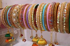 Bangles is an Indian artistic handcraft brand set out to create mesmerizing designs that people would desire to keep and treasure. Every woman is a balance of Beauty, Power & Elegance and we at Bangles aspire to compliment & showcase this Balance. Indian Beauty resides in vibrant colors and soothing elegance, two things that traditionally don't mix together. Elegance demands tranquility while Vibrancy demands energy. 26 Bangles Multi Color Bangles, Wedding Bangles, The Bangles, Bangles Set, Bangles Indian, Bridal Bangles, Bangle Set, Pearl Chain, Silk Thread