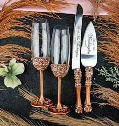 three wine glasses and two knives are sitting next to each other