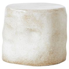 a small white stool sitting on top of a wooden table