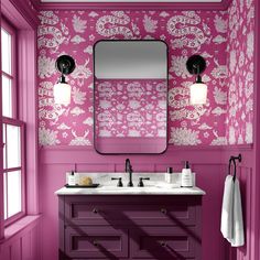 a bathroom with pink and white wallpaper, two sinks and a large mirror on the wall