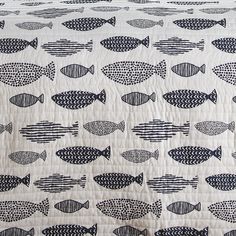 a quilted bed with black and white fish on it