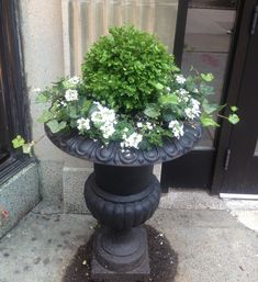 a planter with flowers in it sitting on the sidewalk