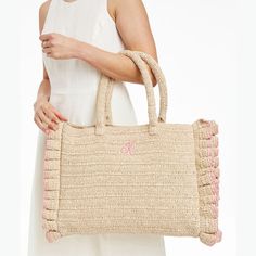 This beach-ready oversized tote, crafted from unlined twisted raffia, is a must-have on sunny days. The durable, structured handle, tassel accessory and playful handcrafted ruffled edging make it stand out, at the shore, by the pool or anywhere you need ample storage for long summer days. A monogram adds a personal touch.    17"w x 4"d x 13"h  Handle drop: 8"  Paper straw and twisted raffia.  Spot clean and store only when completely dry.  Made in India.  Monogramming is embroidered. Natural Color Beach Bag With Tassels For Spring, Natural Tassel Beach Bag For Spring, Natural Color Tassel Beach Bag For Spring, Chic Beach Bag With Rolled Handles For Spring, Spring Straw Beach Bag With Rolled Handles, Spring Beach Straw Bag With Rolled Handles, Chic Straw Bag With Rolled Handles For Spring, Spring Beige Beach Bag With Rolled Handles, Spring Beach Bag With Rolled Handles In Natural Color