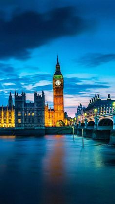 the big ben clock tower towering over the city of london at night with lights on