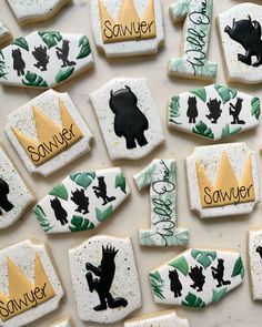 decorated cookies with black silhouettes and name tags on them are arranged in the shape of letters