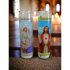 two candles with images of jesus and mary on them