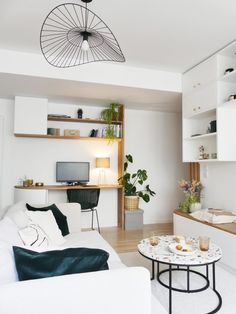 a living room filled with white furniture and lots of bookshelves on the wall