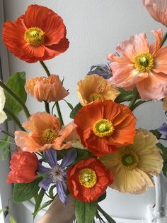 a vase filled with lots of different colored flowers