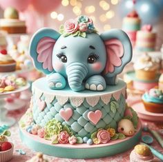 an elephant figurine sitting on top of a blue cake with pink flowers and hearts