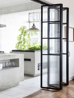 an open kitchen with white walls and black glass doors on the door to the dining room